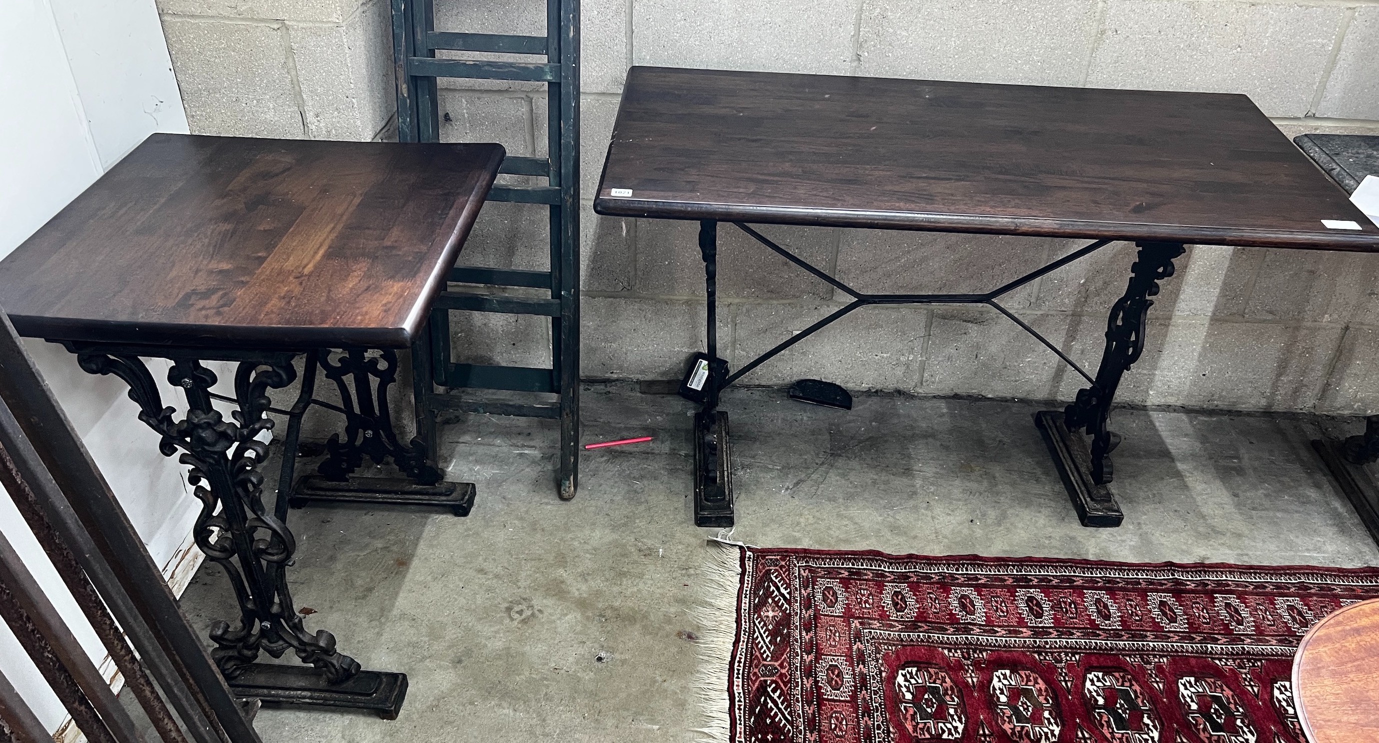 Two Victorian style cast metal stained wood topped tavern tables, larger width 120cm, depth 60cm, height 75cm